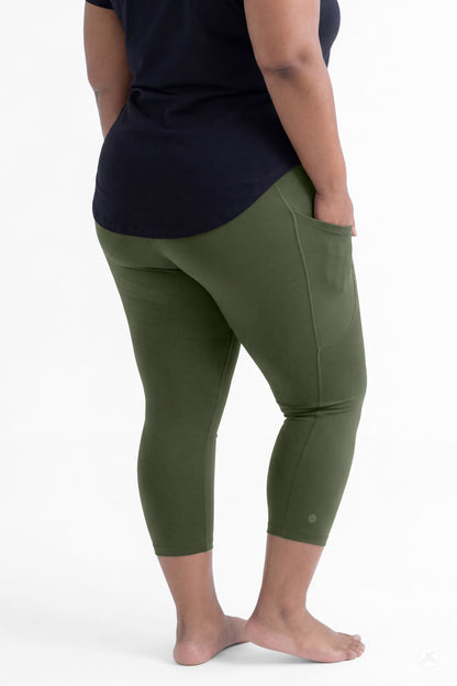 Plus size woman wearing SweetLegs Cedar Pocket Crops in olive green with side pockets and black top barefoot back view