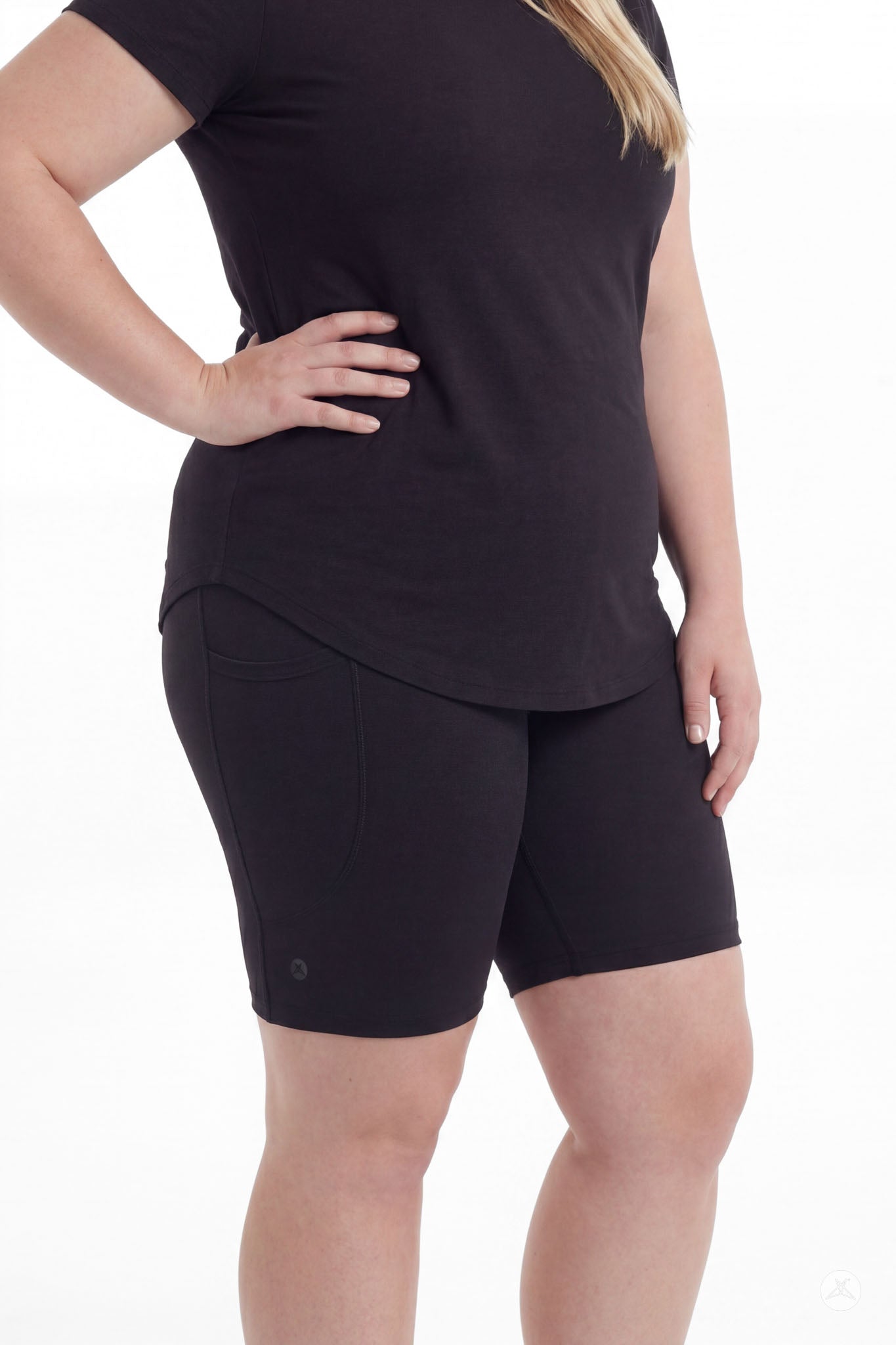 Plus size woman wearing SweetLegs Black Pocket Biker Shorts and black top with hand on hip side view
