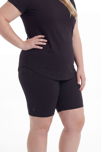 Plus size woman wearing SweetLegs Black Pocket Biker Shorts and black top with hand on hip side view