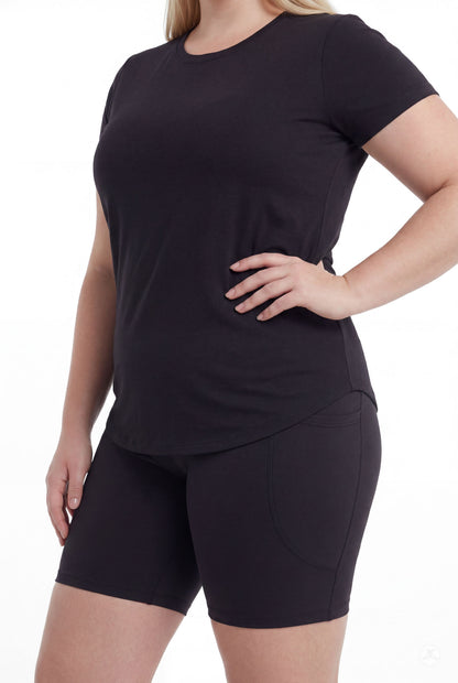 Plus size woman wearing SweetLegs Black Pocket Biker Shorts with black short sleeve top standing side view