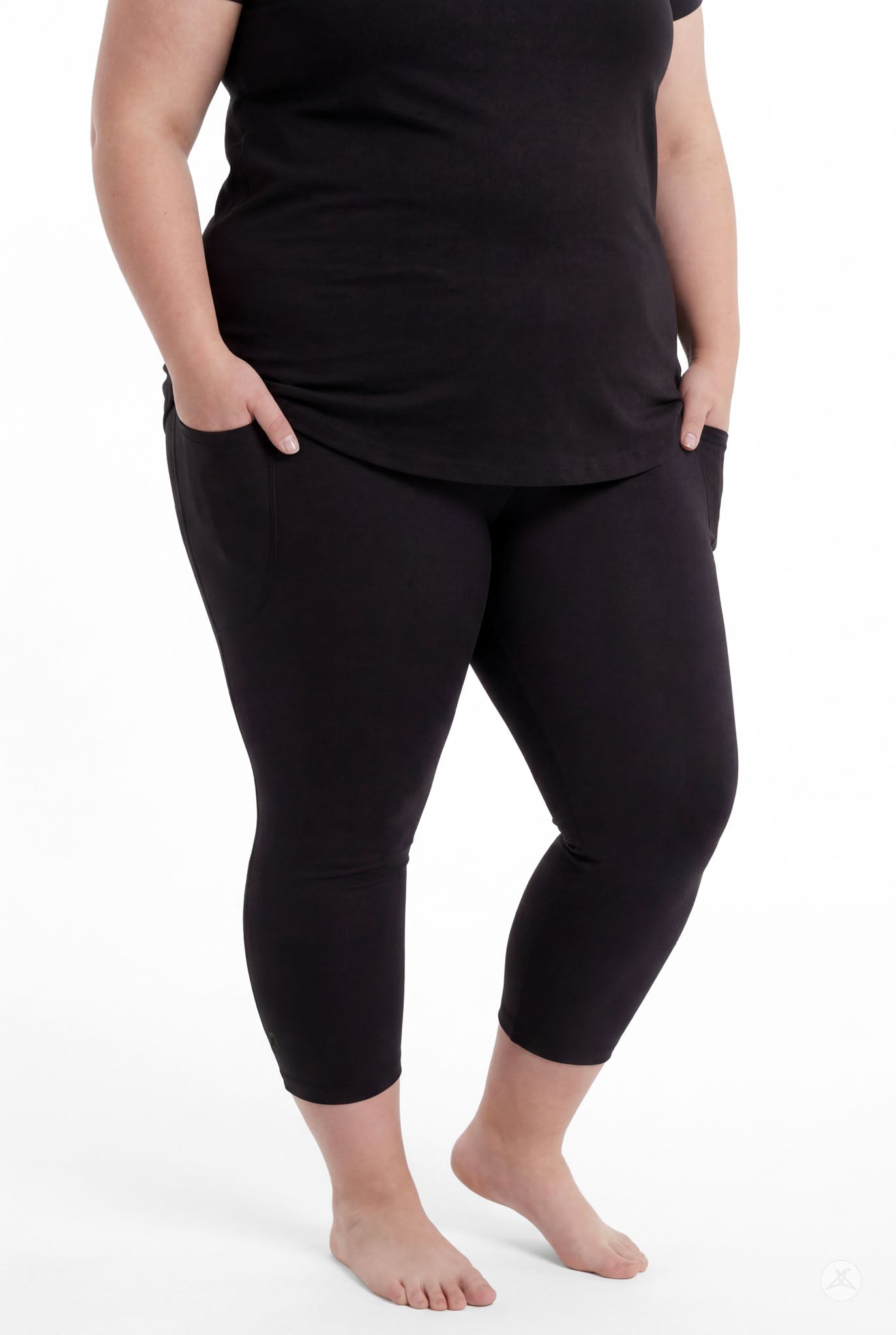 Plus size woman standing barefoot with hands in pockets wearing SweetLegs Black Pocket Crops and black top