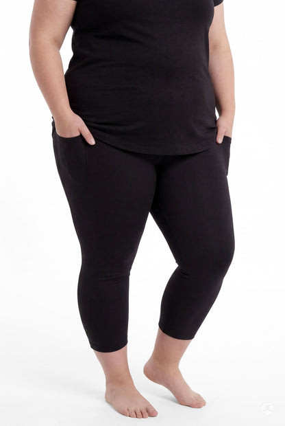 Plus size woman standing barefoot with hands in pockets wearing SweetLegs Black Pocket Crops and black top