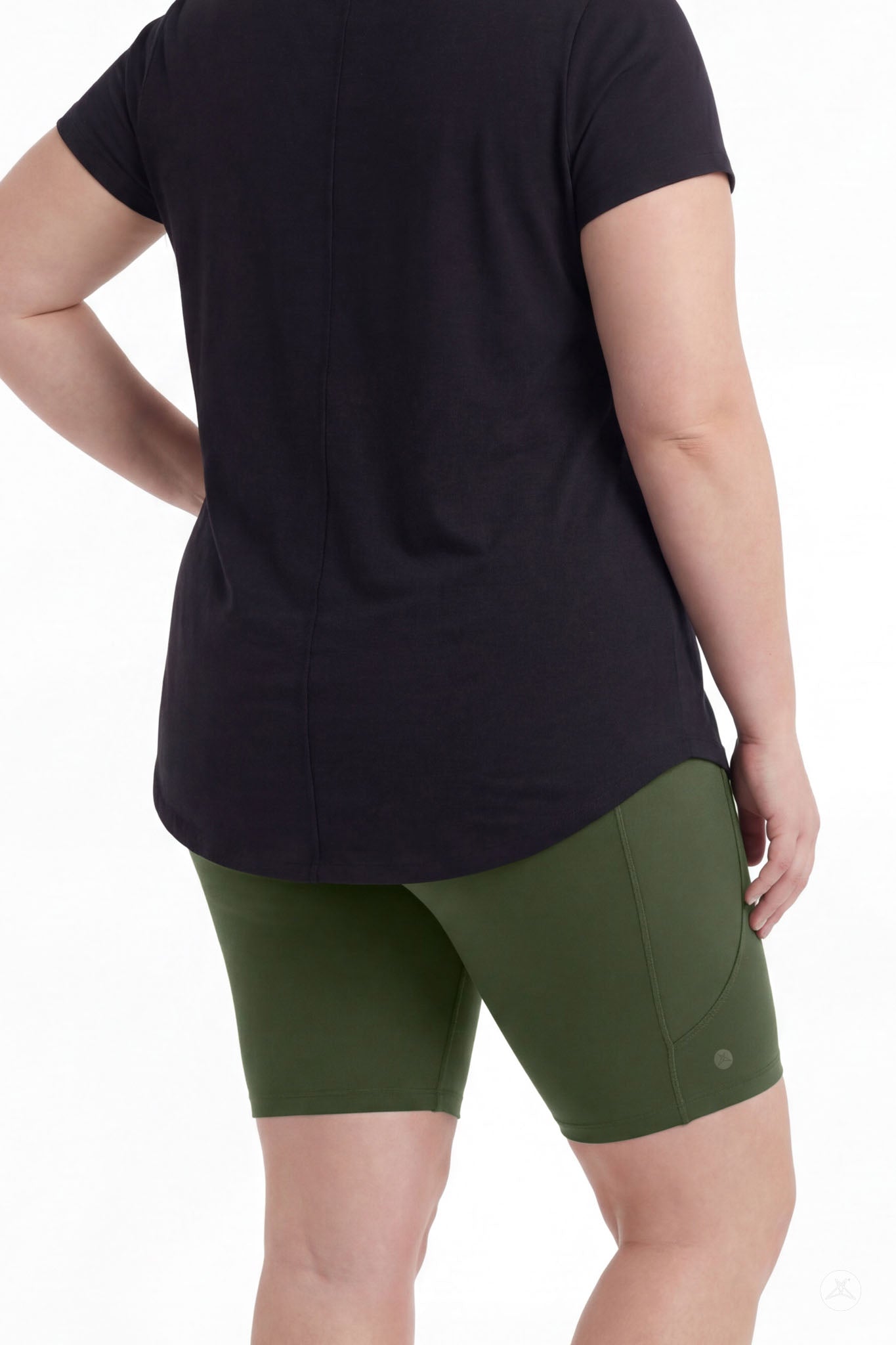 Plus size woman wearing SweetLegs Cedar Pocket Biker Shorts in green standing with hand on hip back view