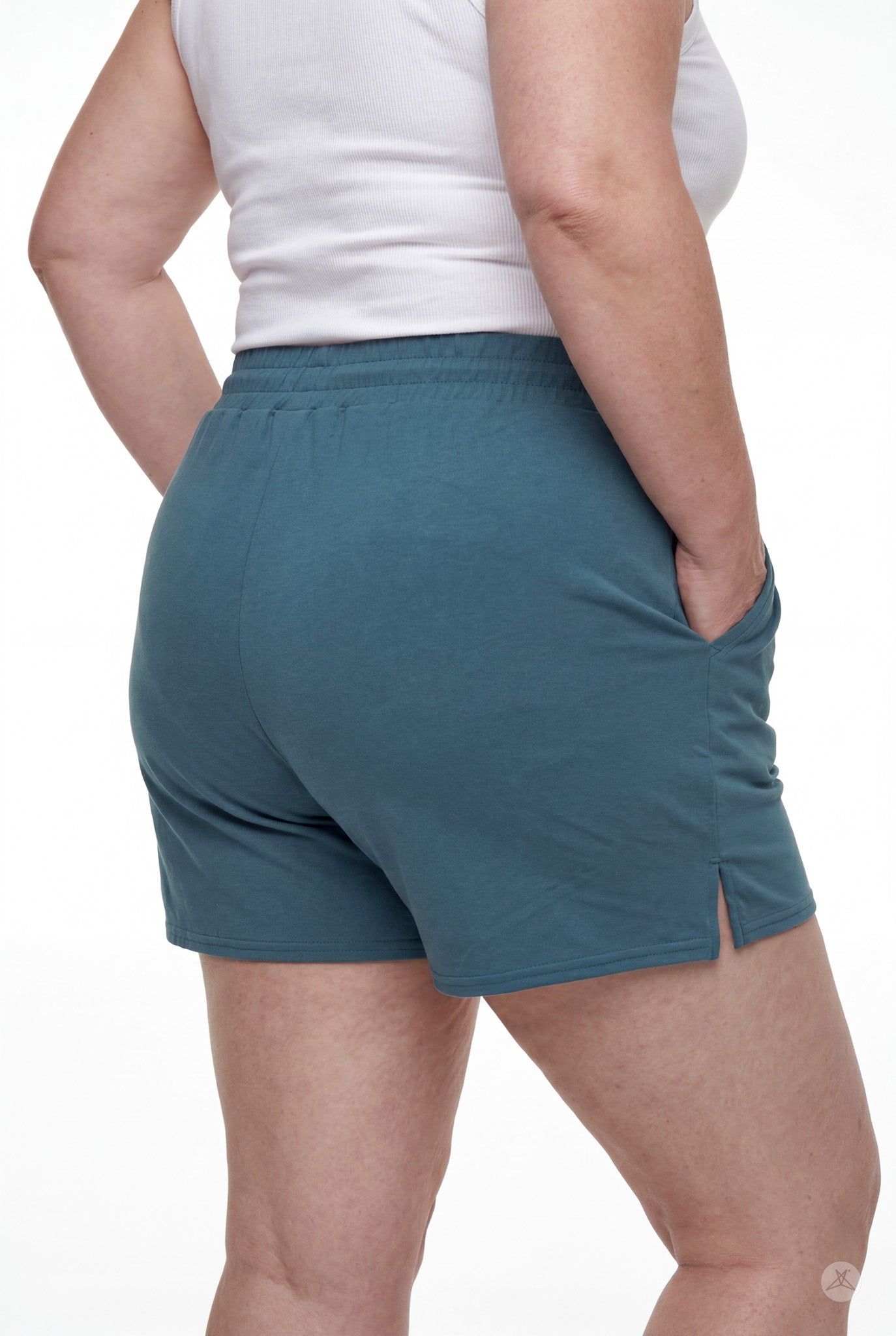 Rear view of person wearing teal Lounge Shorts by SweetLegs with elastic waistband, side slit, and hands in pockets