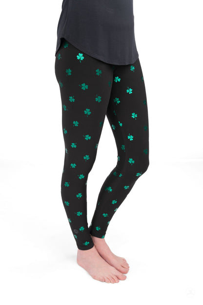Lucky Glow leggings by SweetLegs featuring scattered emerald shamrock print on black fabric with foil accents.