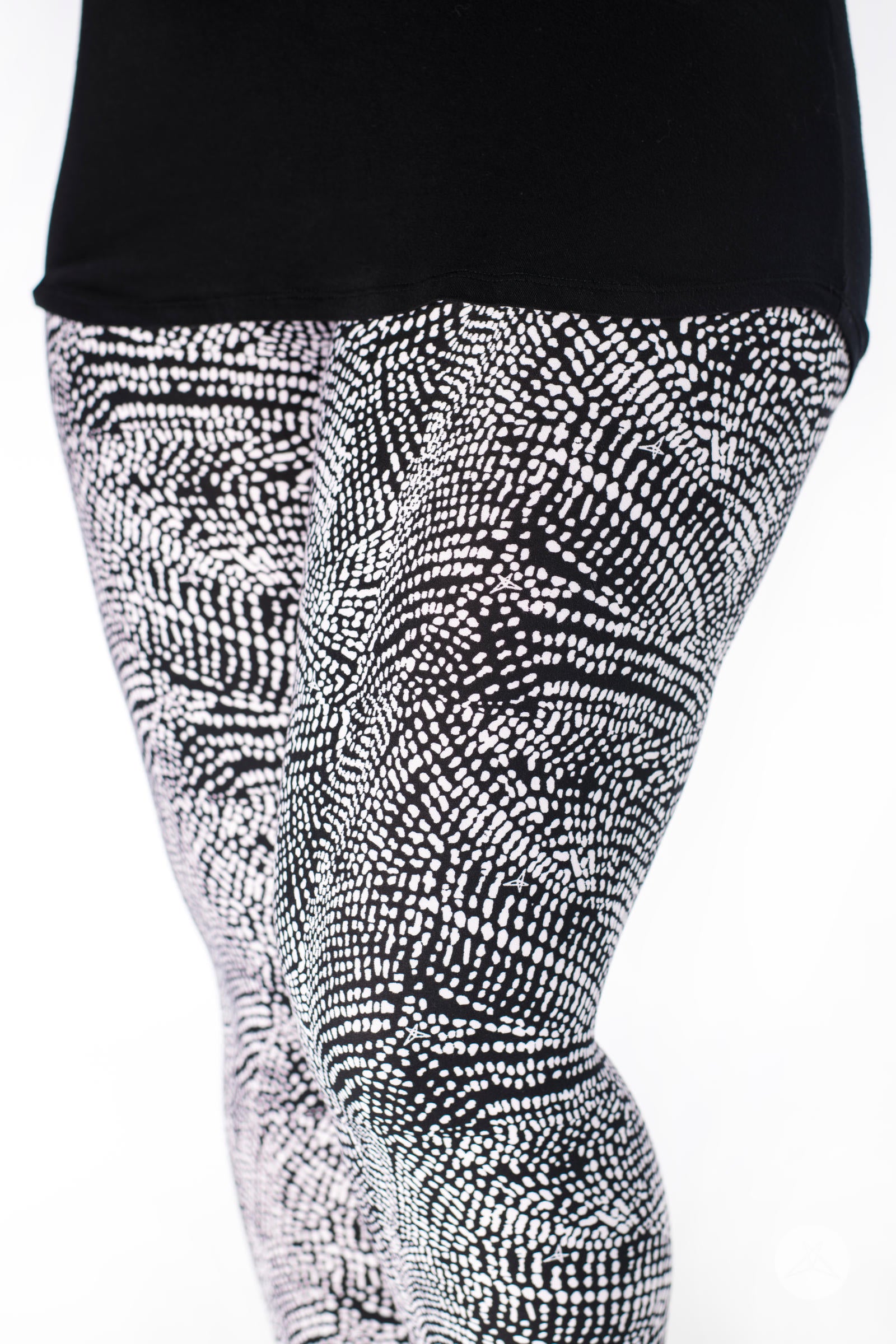 Close-up of SweetLegs Charmed leggings in black and white deconstructed snakeskin pattern on model legs