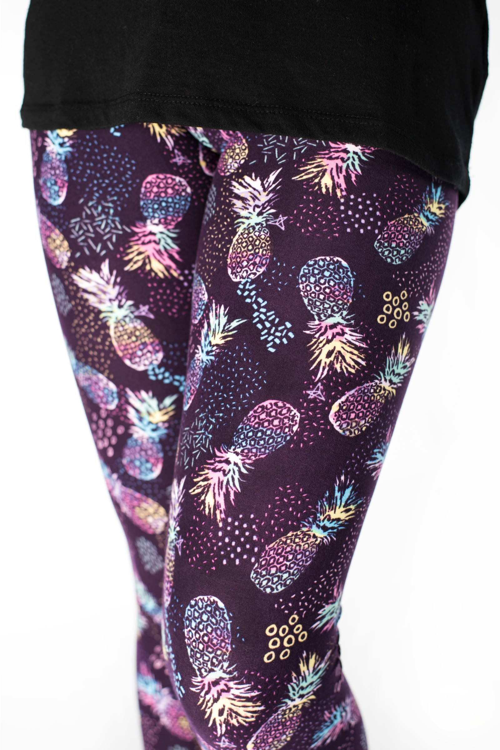 Tropicool Kids leggings by SweetLegs with vibrant multicolor pineapples on a deep purple backdrop in a kid-friendly fit