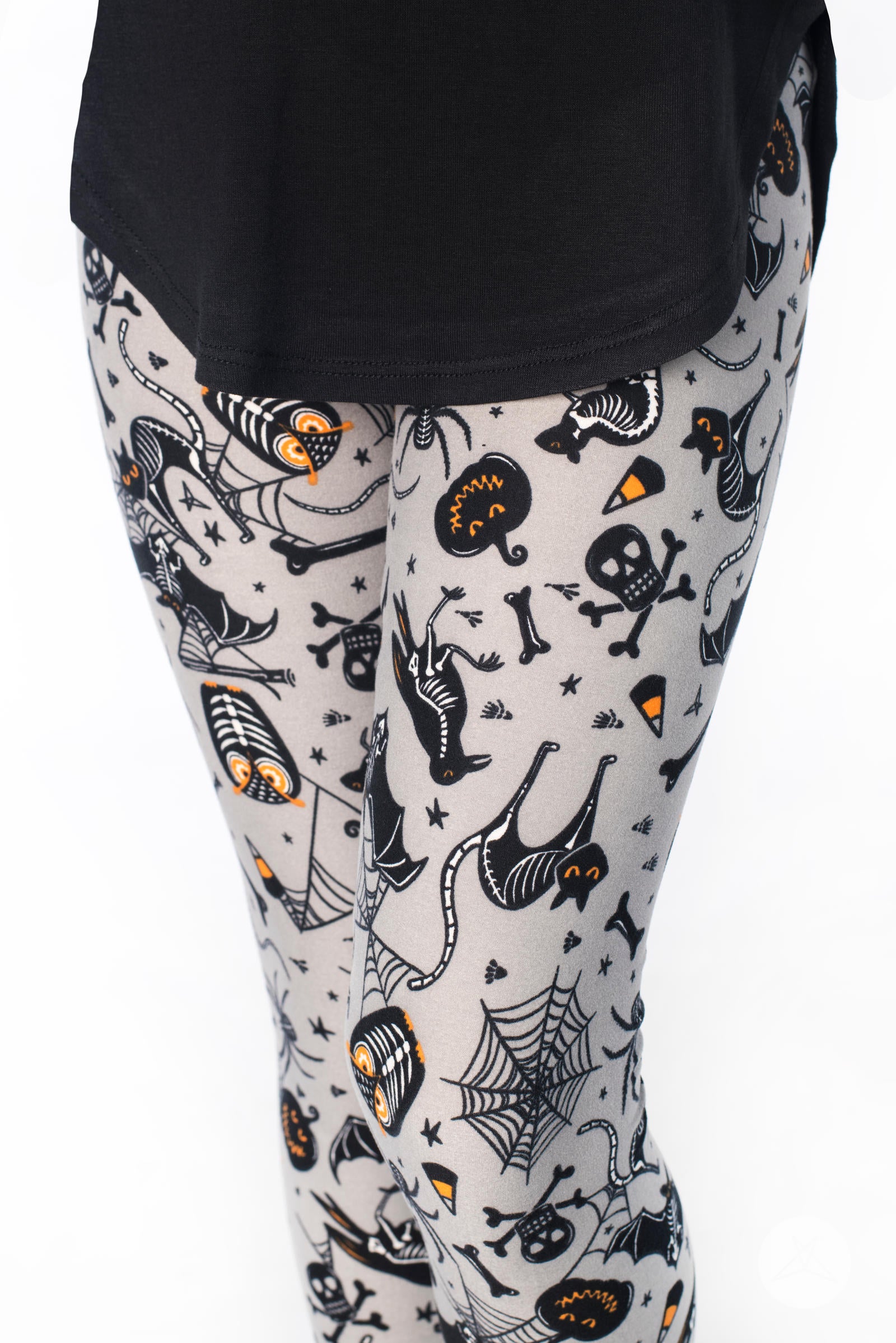 Close-up of kids wearing SweetLegs Spooktacular Kids leggings featuring Halloween skeletons and candy corn print